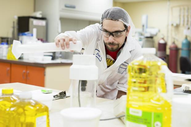 Richardson Oilseed is one of Canada's oldest and largest fully-integrated crushing, refining, processing and packaging operations of Canola and its products. A worker in the company's test lab is shown checking a sample of canola oil.
