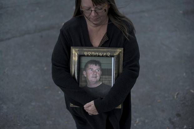 Paulette Raymond cradles a photo of her late brother Tommy while posing in Halifax on Oct. 21, 2017. Mr. Raymond was killed in a work-related accident in 2009.