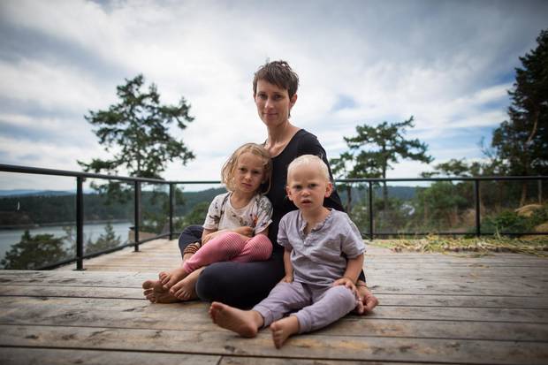 Carina Stone, wife of the late yoga instructor Michael Stone, sits with their children, Olin and Hudson, at their home on Pender Island, B.C.