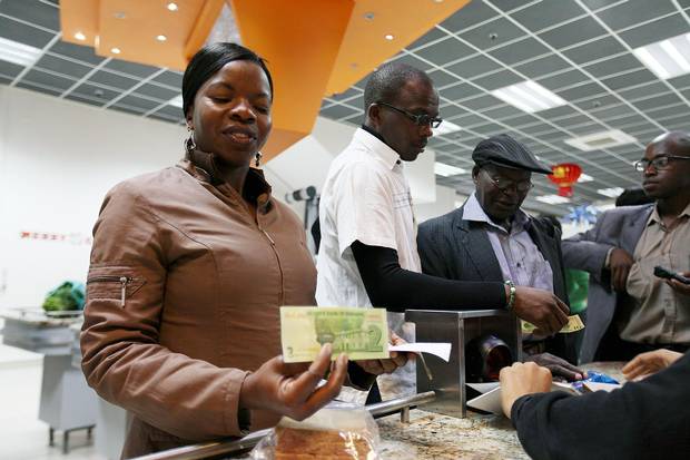 A customer holds a government-issued note that she received as change in a shop in Harare.