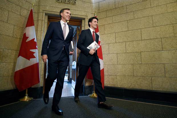 Finance Minister Bill Morneau and Prime Minister Justin Trudeau leave the Prime Minister's office holding copies of the federal budget in Ottawa on March 22, 2017.