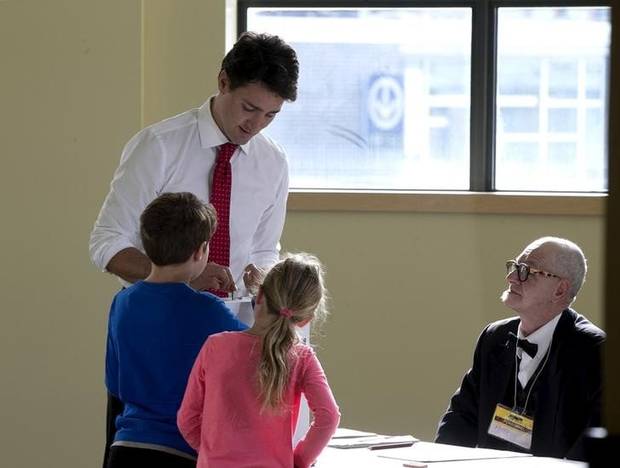 Liberal leader Justin Trudeau casts his ballot at the polling station as his son Xavier and daughter Ella-Grace watch in Montreal, Quebec, October 19, 2015.