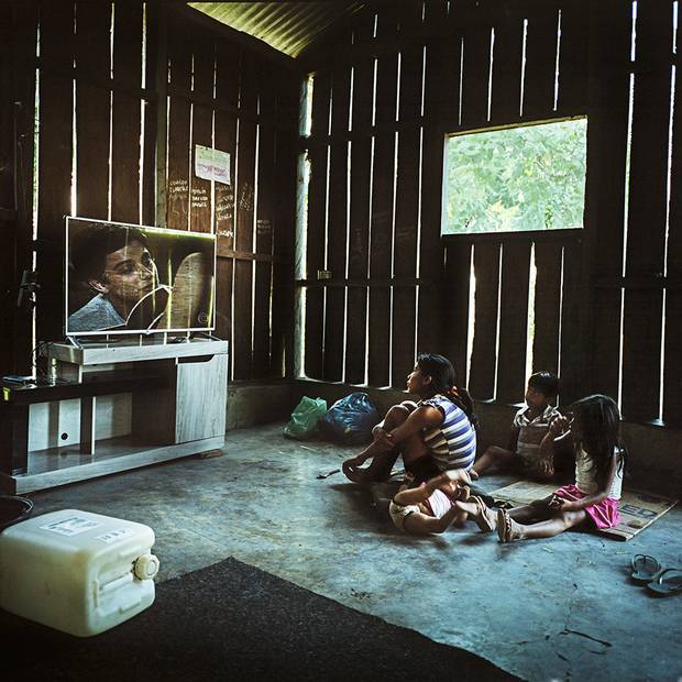 A Munduruku family watches a Brazilian soap opera in the village of Sawre Muybu. Although living completely off the land their villages have generators, fridges and televisions. Many indigenous communities are provided with these goods by government and industry hoping to win their support for the proposed dams.
