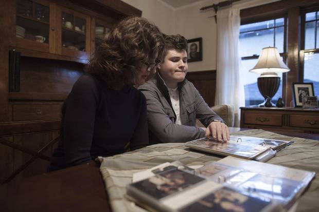 Lola Doyle and her son Jackson look over photographs of Lola's father Barry Hyman at their home in Vancouver.