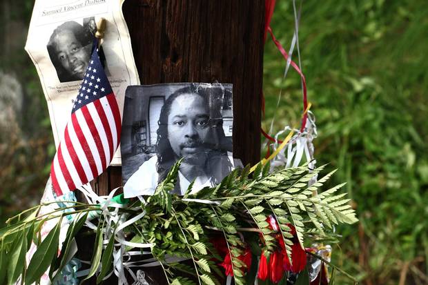 In this July 29, 2015, file photo, photos of Samuel DuBose hang on a pole at a memorial near where he was shot and killed by a University of Cincinnati police officer.