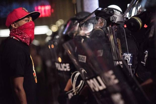 A demonstrator confronts police officers in riot gear on Sept. 22, 2016, in downtown Charlotte, N.C.