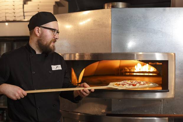 Chef Neil Royale places a pizza in the oven at Die Pie on Wednesday.