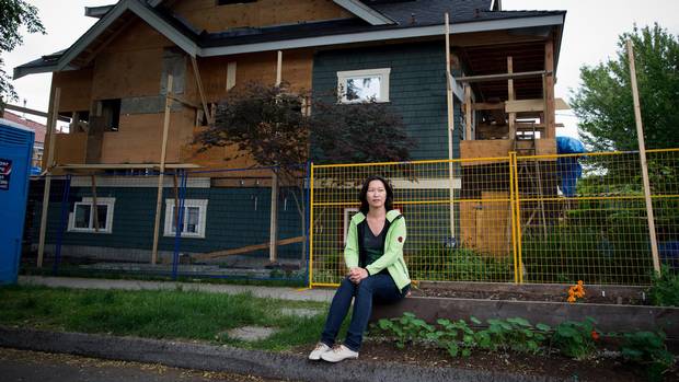 Eveline Xia sits for a photograph near a house being renovated in the community where she lives in East Vancouver, B.C., on Monday May 25, 2015.