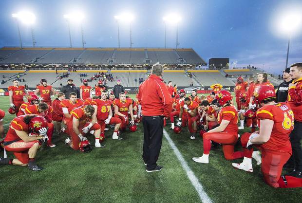 Calgary Dinos head coach Wayne Harris takes a moment with his team after being defeated by the Laval Rouge et Or following the U Sports Vanier Cup football championship in Hamilton last year.