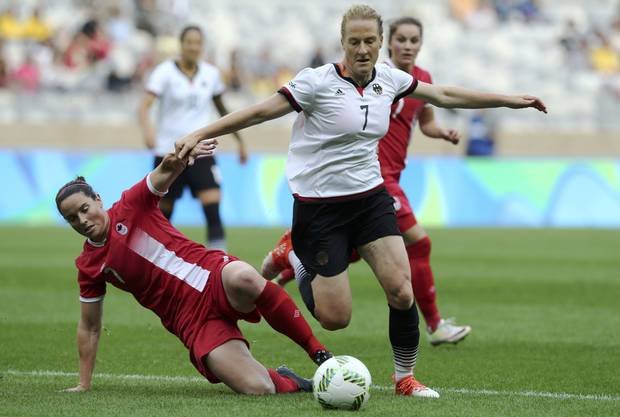 Rhian Wilkinson (CAN) of Canada falls as she fights for the ball with Melanie Behringer (GER) of Germany.