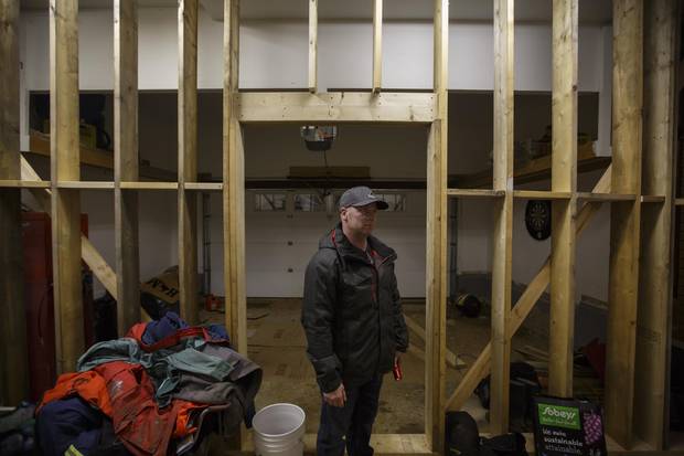 Kirby Byrne stands next to a support wall in the garage, intended to mitigate structural damage, after the family was forced to move out of their Fort McMurray house.