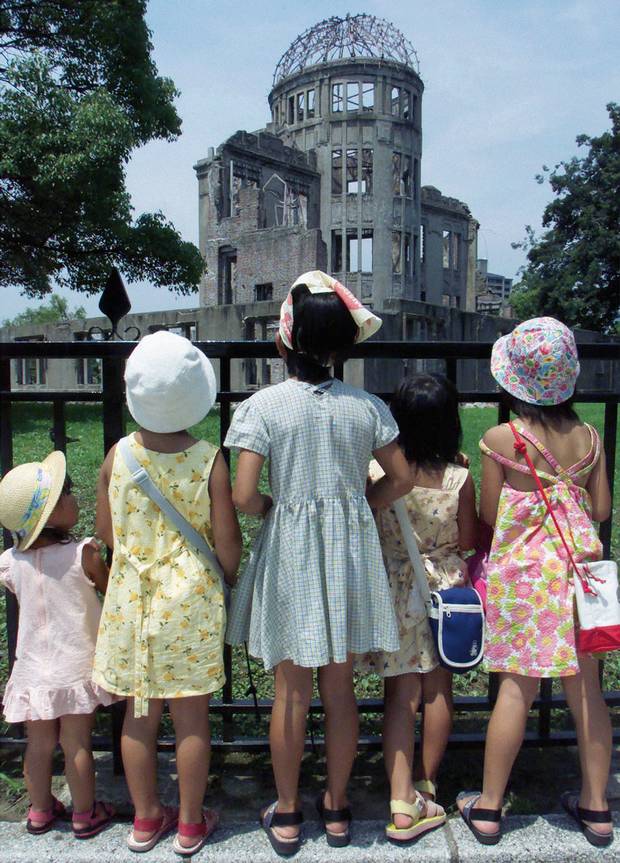Japanese children look up at the Atomic Bomb Dome in Hiroshima Peace Memorial Park, Japan, August 5, 2000, on the eve of the 55th anniversary of the world’s first atomic bombing. More than 140,000 people were killed and many more injured after the United States dropped an atomic bomb on the Japanese city of Hiroshima on August 6, 1945. Three days later a second atom bomb was dropped on Nagasaki.