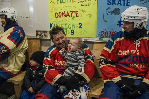 On his break during the World's Longest Hockey Game, Dan Todd sits with his children, six-month-old Cohan and three-year-old Emmett.