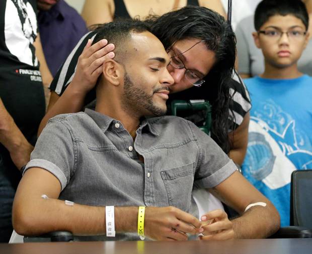 Angel Colon, a victim of the Pulse nightclub shooting, is kissed by his sister while attending a news conference at the Orlando Regional Medical Center Tuesday.