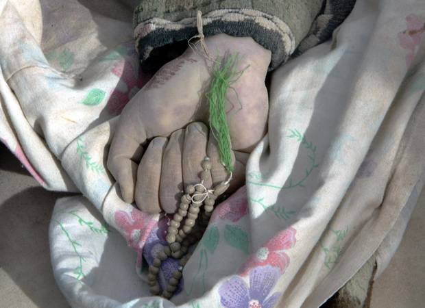 Worry beads remain in the hand of a man who died praying in Bam, Iran, on Dec. 27, 2003.