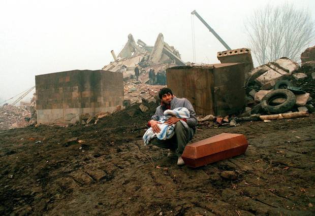 A man holds the body of his child killed during a devastating earthquake in Armenian city of Leninakan, then part of the Soviet Union's Republic of Armenia, on Dec. 10, 1988.