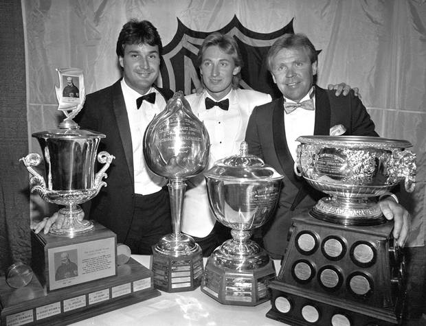 Edmonton Oilers Paul Coffey, left, Wayne Gretzky and coach Glen Sather pose with the four awards they picked up at the annual NHL Awards in Toronto on June 10, 1986.