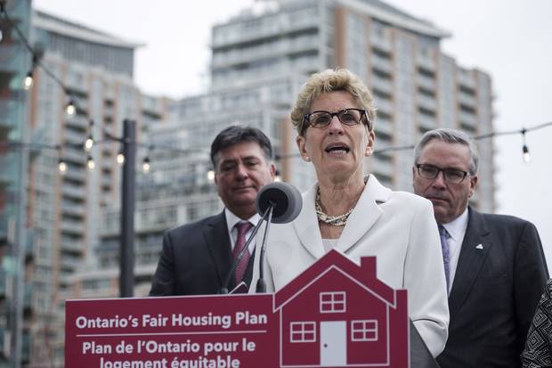 Ontario Premier Kathleen Wynne, middle, is joined by Ontario Finance Minister Charles Sousa, left, and Ontario Housing Minister Chris Ballard in Toronto to speak about Ontario's Fair Housing Plan on April 20, 2017.