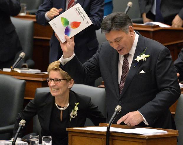 Ontario Finance Minister Charles Sousa, right, delivers the Ontario 2016 budget next to Premier Kathleen Wynne, left, at Queen's Park in Toronto on Feb. 25, 2016.