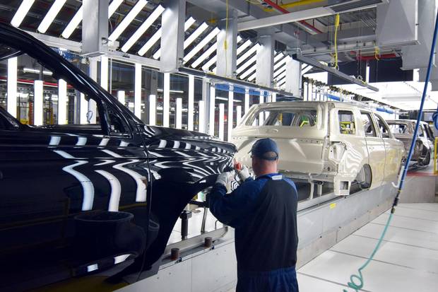 A Ford worker inspects paint work on the body of a Ford Expedition SUV at a plant in Louisville, Ky., on Feb. 9, 2018.
