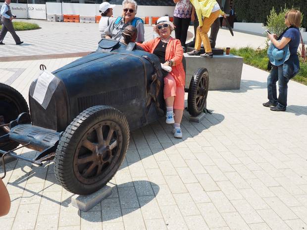 Tourists from Argentina pose in a bronze-cast Bugatti 35 GP, created by artist Francois Chevalier and built in 2016.