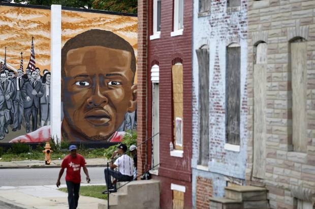A mural depicting Freddie Gray is seen past blighted row homes in Baltimore on June 23, 2016, at the intersection where Mr. Gray was arrested.
