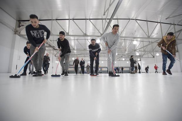 Refugees are photographed during a day trip to the Royal Canadian Curling Club where they had their first curling experience, on March 15, 2017.