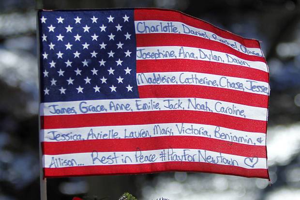 Dec. 28, 2012: A flag in Newtown bears the names of the dead. Twenty children and six adults at the school were killed by a gunman who had earlier killed his mother, and finally killed himself.