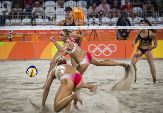Canadians Heather Bansley and Sarah Pavan scramble for the ball after a successful spike by Swiss players Nadine Zumkehr and Joana Heidrich in preliminary beach volleyball action at Rio Olympics August 10, 2016. (John Lehmann/The Globe and Mail)