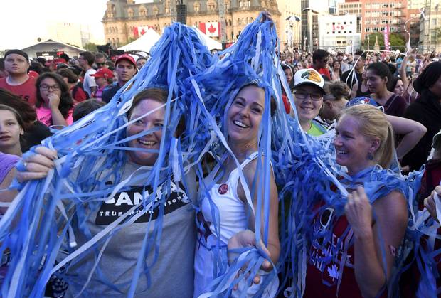 Spectators are tangled up in confetti streamers after a performance at We Day on Parliament Hill, in Ottawa on Sunday, July 2, 2017