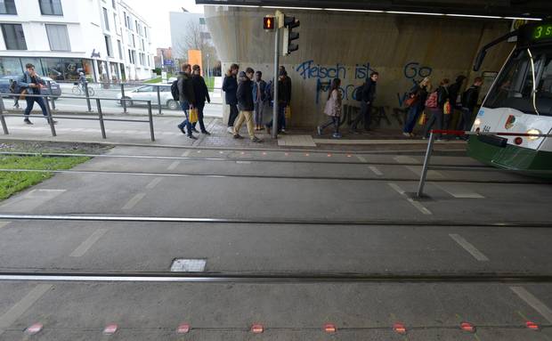 Traffic lights are embedded in the streets to warn pedestrians using their phones in Augsburg, Germany.