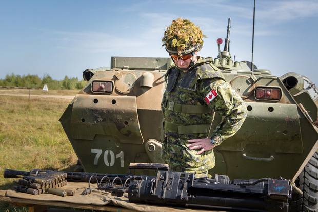 A Canadian soldier examines an automatic APC cannon before a drill in Yavoriv, Ukraine. Canadian trainers are helping Ukraine modernize its tactics to combat pro-Russian separatists.