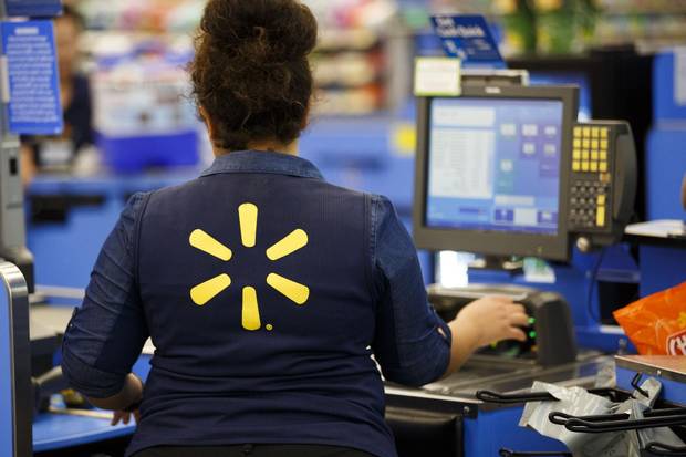 An employee scans items at a cash register at a Wal-Mart Stores Inc. location in Burbank, Calif., Tuesday, Aug. 8, 2017.