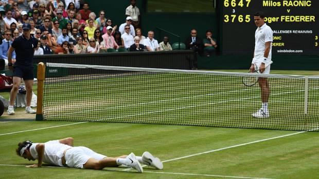 Switzerland's Roger Federer lies on the court after falling while trying to return to Canada's Milos Raonic during their men's semi-final match on the twelfth day of the 2016 Wimbledon Championships.