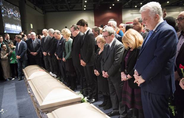 Prime Minister Justin Trudeau, Quebec City mayor Regis Labeaume and Quebec Premier Philippe Couillard gather in front of caskets of three of the six victims on Feb. 3, 2017.