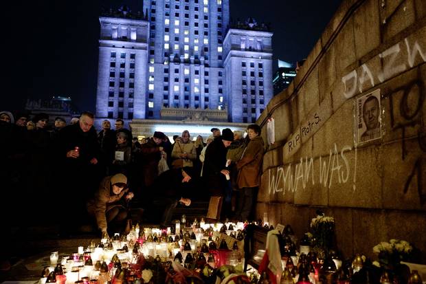 Nov. 6, 2017: People gather and lay candles in the place where Piotr Szczesny killed himself. They hold papers reading ‘I, the everyman.’
