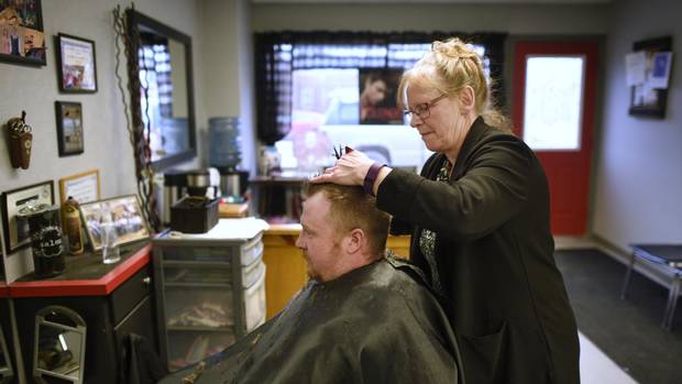 Cathy Slear, co-owner of the Creative Hair Boutique in Shelburne, trims Jeff Coyle's hair. Slear believes a bowling alley would be a good addition to the town since there's not much for people to do locally. Coyle lives in nearby Honeywood but has also noticed the recent growth in the population of Shelburne.