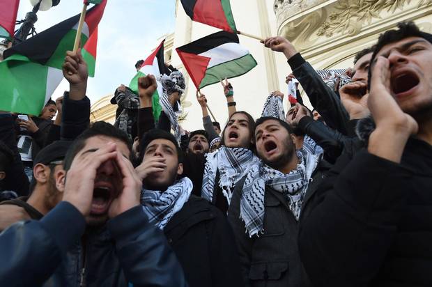 Tunisian demonstrators shout slogans and wave Palestinian flags during a demonstration in Tunis.