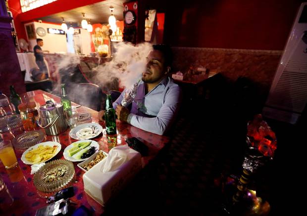 People have drinks and smoke shisha at a bar in the town of Qaraqosh, south of Mosul, Iraq July 18, 2017.