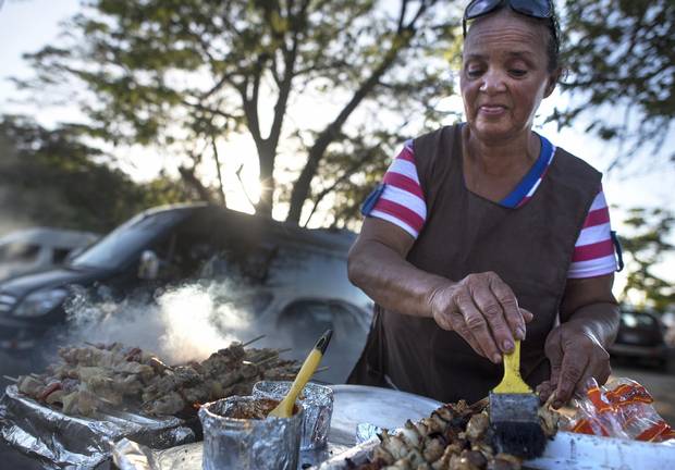 Mary, a street food vendor, cooks and sells grilled chicken and pork on Calle Central.