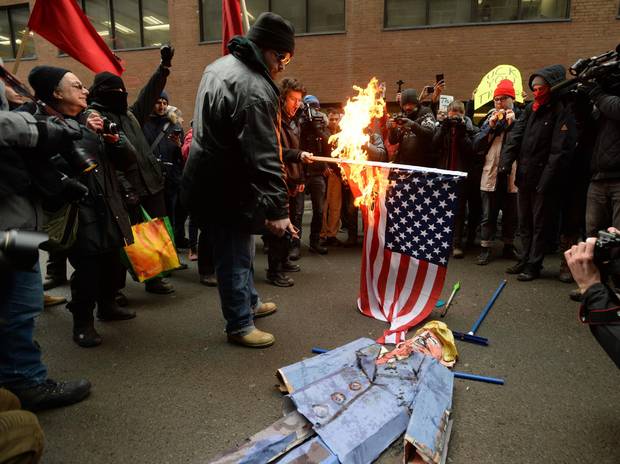 Anti-Trump protesters burn an effigy of Donald Trump in the streets of Montreal on Friday.