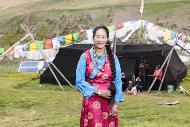 Leray's daughter poses in her traditional Tibetan clothing in front of her family's black yak wool tent.