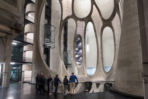 In the silos, a dramatic central atrium had to be hewn, along with 80 white-walled galleries, two tubular elevator shafts and a spiral staircase dropped in from the top like a corkscrew.