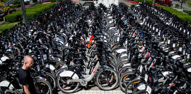 A PBSC Urban Solutions worker walks past hundreds of BIXI bikes parked outside the Sheraton Wall Centre for delegates of the Velo-city Global 2012 conference to use in Vancouver, B.C., on Monday June 25, 2012.