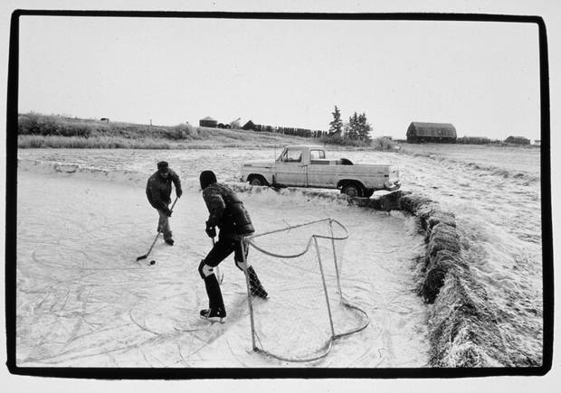 Iconic images like this one were commonplace in the Prairies. All you had to do was take the time to stop. This picture had it all – two old friends, the old Lange skates, a hand-hewn rink rimmed in hay bales – what could be better?