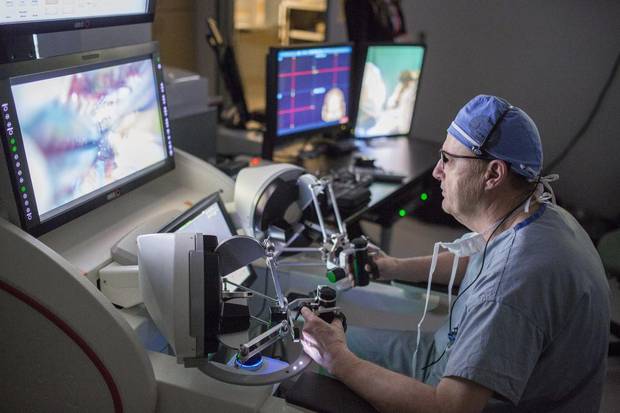 Neurosurgeon Dr. Garnette Sutherland performs a brain surgery using the NeuroArm.