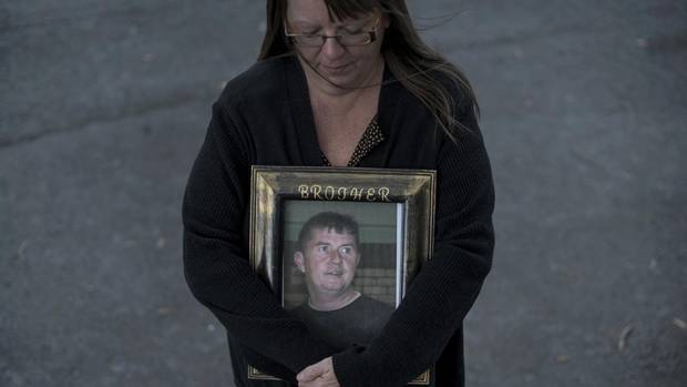 Paulette Raymond cradles a photo of her late brother Tommy who was killed in a work-related accident in 2009