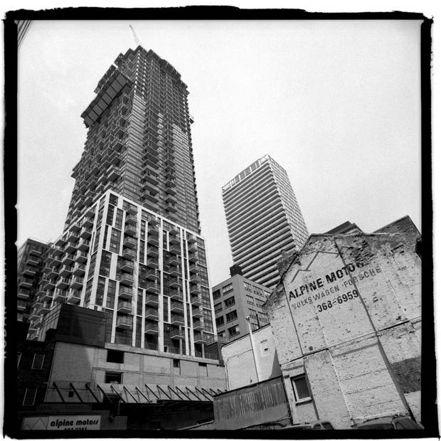 A condo building dwarfs a smaller, older building in Toronto’s King-Spadina district, near King Street West and John Street. The neighbourhood is undergoing a massive building boom.