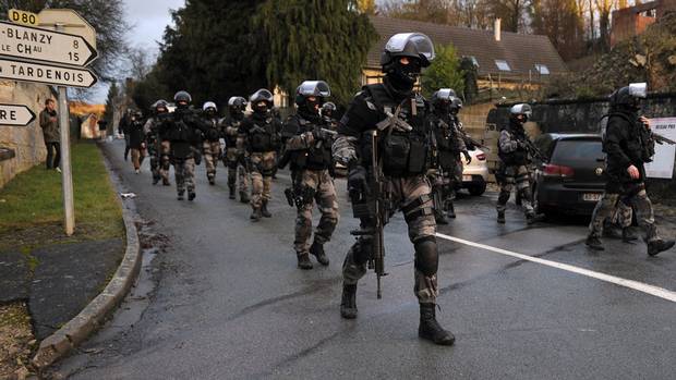 French police special forces walk in Corcy, northern France, on January 8, 2015 as they carry out searches.