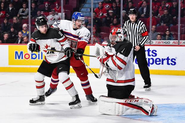 Goaltender Connor Ingram of Team Canada makes a makes a save while teammate Kale Clague and David Kase of Team Czech Republic battle for position during the 2017 IIHF World Junior Championship quarterfinal game at the Bell Centre on January 2, 2017 in Montreal, Quebec, Canada.